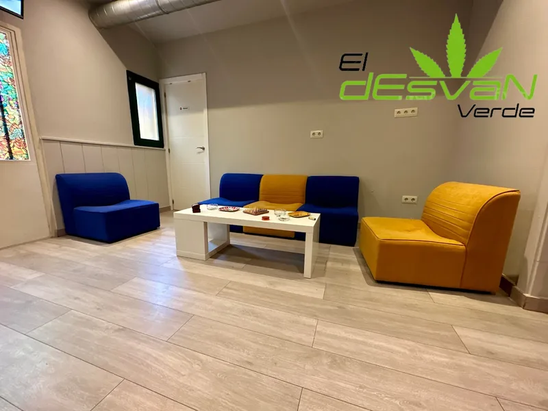 Seating area at El Desván Verde cannabis social club Madrid with comfortable chairs and tables